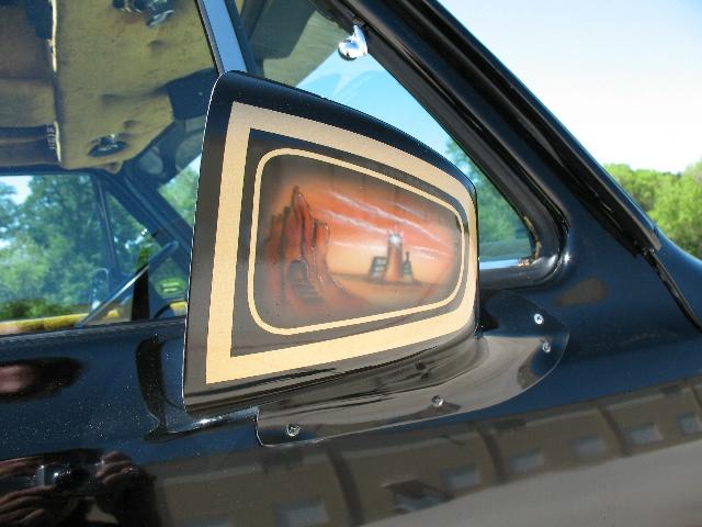 Black vehicle side mirror with custom airbrushed desert landscape and lighthouse scene