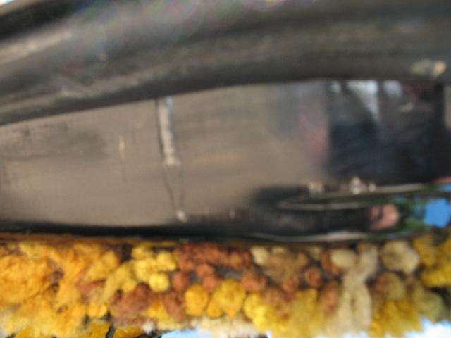 Close-up of textured material and a reflective surface, possibly from a vehicle interior