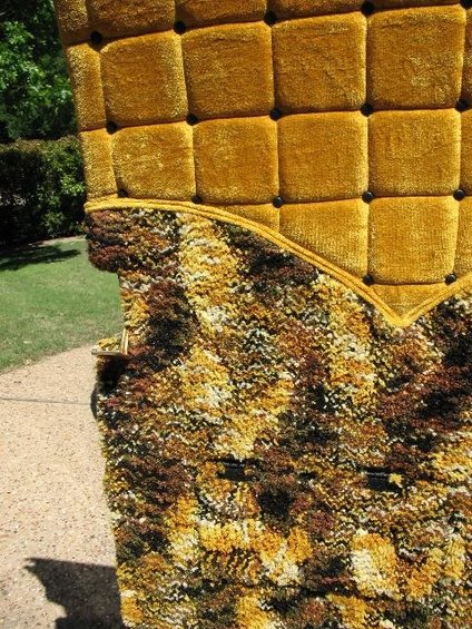 Yellow tufted upholstery with a patterned fabric trim