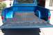 1976 Chevrolet C/K Pickup - Rear view of a blue pickup truck bed, showing the tailgate down and the interior lining.