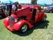 2002 Ford Mustang - A bright red hot rod is displayed with its hood and door open at an outdoor event, its engine and interior.