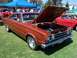 2002 Ford Mustang - Orange 1967 Plymouth GTX coupe at a car show, hood open, revealing the engine bay.