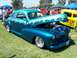 2002 Ford Mustang - A custom hot rod with a two-tone teal and blue paint job flame graphics is displayed with its hood open.