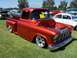 2002 Ford Mustang - A customized pickup truck is displayed on a grassy field with other vehicles present.