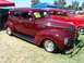 2002 Ford Mustang - A maroon sedan from the 1930s is parked on a grassy field next to another classic car.