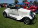 2002 Ford Mustang - A white convertible roadster is parked on grass at a car show with other vehicles in the background.