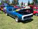 2002 Ford Mustang - A blue 1967 Chevrolet Camaro is displayed with its hood open at an outdoor car show.