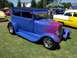 2002 Ford Mustang - A custom blue sedan with flame graphics sits on a grassy field next to other vehicles.