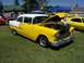 2002 Ford Mustang - A classic yellow and white Chevrolet sedan is displayed with its hood up at an outdoor event.