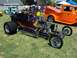 2002 Ford Mustang - A custom hot rod with a powerful engine is displayed at an outdoor car show with other vehicles present.