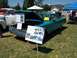 2002 Ford Mustang - A teal 1959 Ford Fairlane 500 Skyliner is displayed with its hood open at an outdoor event, alongside a white truck.