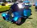 2002 Ford Mustang - A custom blue hot rod is displayed outdoors with its hood open, alongside other vehicles and tents.
