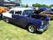 2002 Ford Mustang - A customized 1955 Chevrolet Bel Air with flame graphics is displayed at an outdoor event.