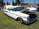 2002 Ford Mustang - A white 1957 Chevrolet Bel Air 2-door hardtop is displayed with its hood open at an outdoor event.