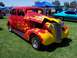 2002 Ford Mustang - A custom hot rod with flame paintwork is displayed outdoors with other vehicles.
