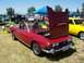 2002 Ford Mustang - A red convertible with its hood open is displayed at an outdoor car show next to a yellow car.