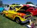 2002 Ford Mustang - Customized 1955 Chevrolet pickup truck with flame graphics and open hood at a car show.