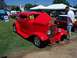 2002 Ford Mustang - A bright red classic coupe is displayed with its hood up at an outdoor car show.