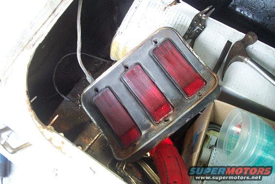 car tail light assembly with three red lenses, tools nearby