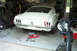 1968 Ford Mustang - A white 1968 Ford Mustang is parked in a garage, with tools scattered around its rear.