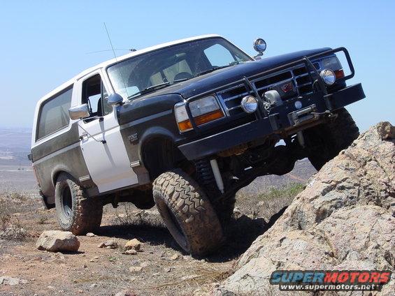 1994 Ford Bronco climbing over rocks on a trail