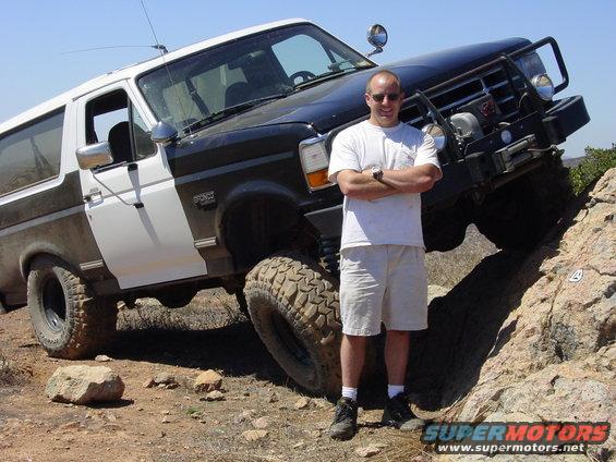 Two-tone black and white Ford Bronco with off-road tires on rocky terrain