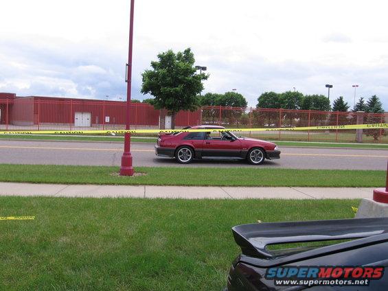 Red 1989 Ford Mustang coupe side view with spoiler