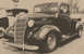 1940 Chevrolet Suburban - A vintage Chevrolet pickup truck is parked next to another vehicle, with a sign in the background.
