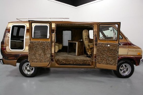 Brown and tan custom van with shag carpet interior, doors open, 3/4 front view