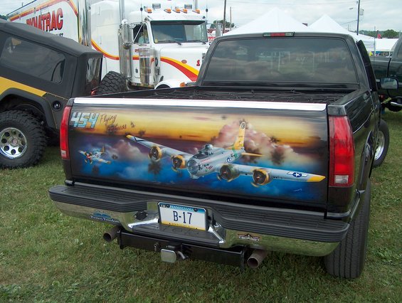 Pickup truck tailgate painted with B-17 bombers flying through clouds at sunset