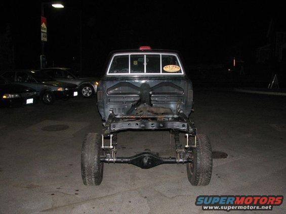 1994 Toyota Tacoma chassis viewed from rear at night, with other cars parked nearby