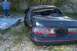 1992 Ford Mustang - A dark sedan with a damaged rear end sits in a gravel lot.