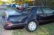 1992 Ford Mustang - This black coupe shows significant damage to its rear quarter panel and trunk area, with other vehicles visible in the background.