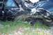 1992 Ford Mustang - This heavily damaged 1992 Ford Mustang sits off the road, its rear wheel assembly detached.