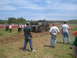 1989 Ford Bronco - A lifted pickup truck navigates a muddy track during an event, with spectators gathered to watch.