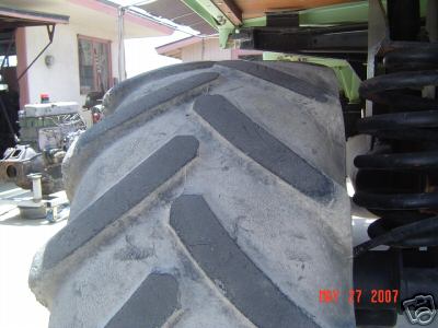 Close-up of a large tractor tire and heavy-duty suspension components