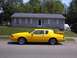 1986 Mercury Cougar - A bright yellow 1986 Mercury Cougar LS is parked on the street in front of a modest house.