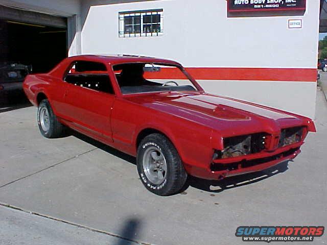 Red 1967 Mercury Cougar parked outside a body shop