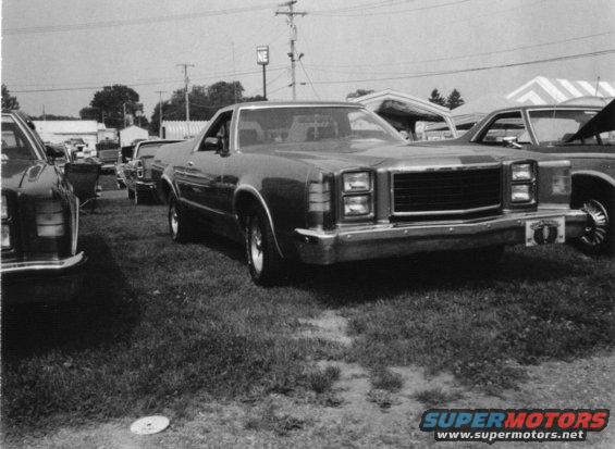 Front view of a 1979 Ford Ranchero parked on grass with other vehicles nearby