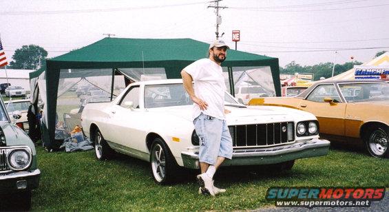 Man posing with a white 1977 Ford Ranchero. Another Ranchero is parked next to it