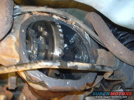 Differential gears covered in grease, with visible rust on surrounding components