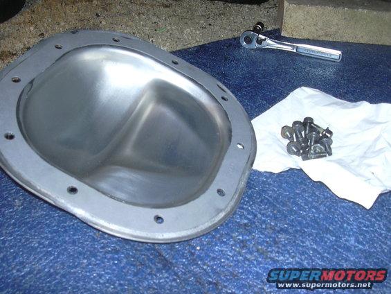 Differential cover and bolts with a ratchet on a blue surface