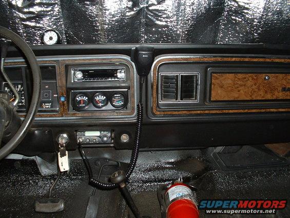 1978 Ford Bronco interior showing dashboard, steering wheel, gauges, radio, and fire extinguisher