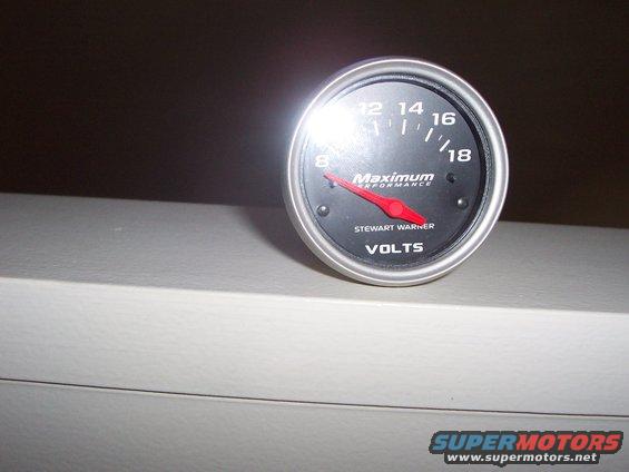 Stewart Warner volts gauge with red needle pointing to 8