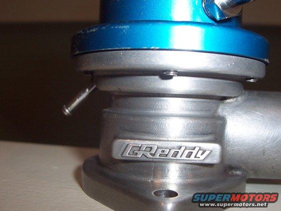 GReddy blow-off valve with blue top and silver body, showing a metal badge