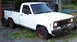 1971 Porsche 914 - A white pickup truck sits parked on a gravel surface with overgrown grass.