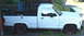 1971 Porsche 914 - A white pickup truck is parked on the side of the road, showing its full profile.