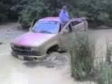 1990s Chevrolet pickup truck stuck in mud, driver's door open