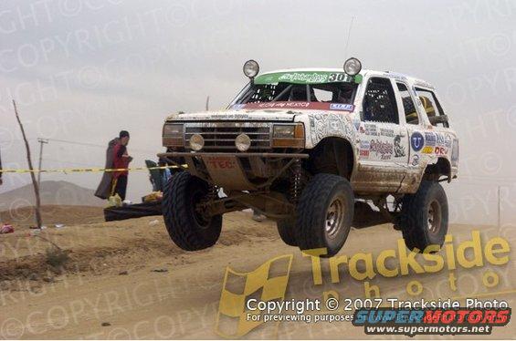 1992 Ford Explorer modified for off-road racing, airborne over a dirt track