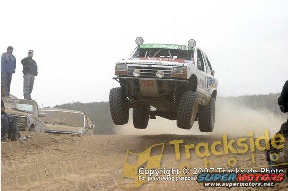 1992 Ford Explorer mid-air jump, front 3/4 view, white with racing decals
